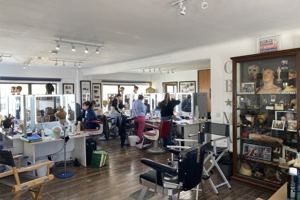 CBMA 4-month course students working on makeup application and period wig styling during class